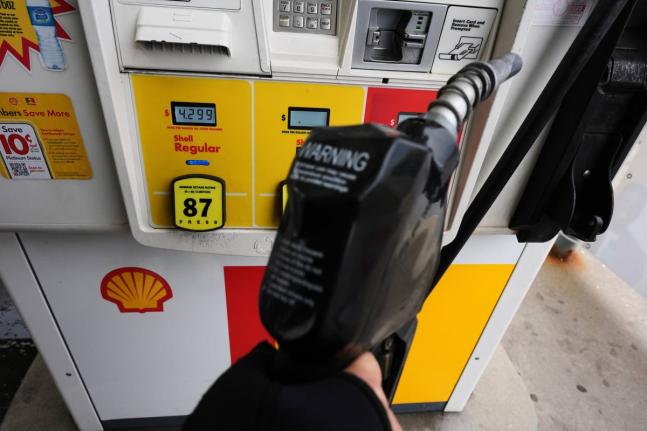 AP
A gas price is displayed as a customer holds a fuel pump nozzle before filling up her vehicle’s gas tank in Lincolnshire, Illnois, on April 15.  