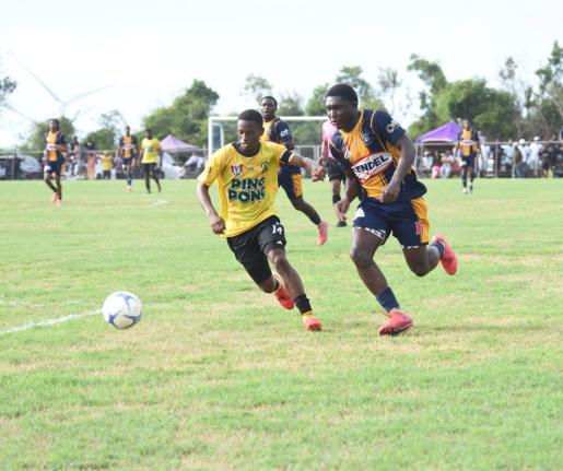 Munro College’s Izion Fraser (right) tries to outpace Black River High’s De Shawn Smith during their ISSA daCosta Cup Zone D preliminary round match at Munro playfield yesterday.