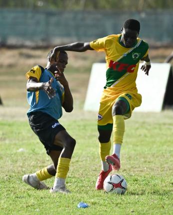 Kingston Technical High School’s Richard West (left) tries to get close to Excelsior High School’s Aldeano Walters during their Walker Cup football encounter at Excelsior High’s playing field on September 26.