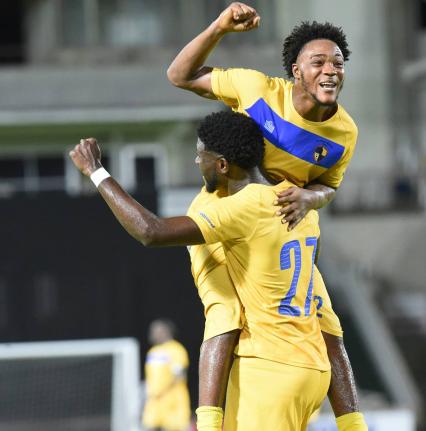 Kadean Young (right) of Racing United, celebrates with a teammate after scoring his team’s fifth goal against Molynes United in their 6-0 win at Sabina Park yesterday.