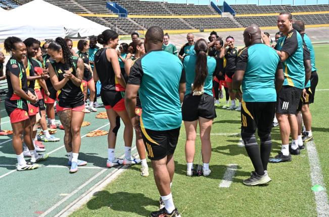 Hubert Busby Jr (right), head coach of the  Reggae Girlz, speaks with the team during a training session ahead of the  Jamaica vs Guyana match at the National Stadium on Friday, April 17, 2026. 