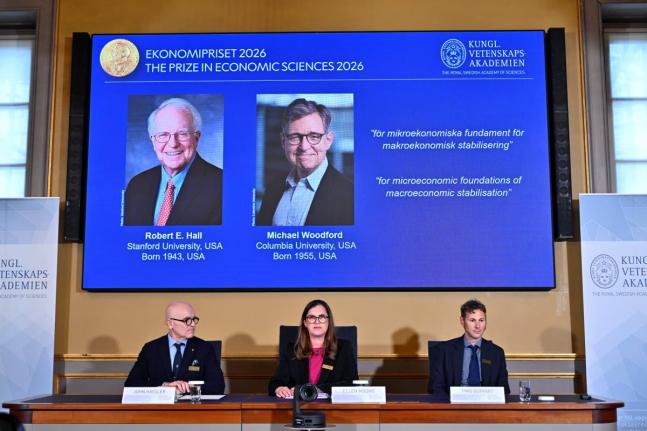 Portraits of Robert E. Hall and Michael Woodford are shown on the screen as they are announced as the laureates of the Sveriges Riksbank Prize in Economic Sciences in Memory of Alfred Nobel at the Royal Swedish Academy of Sciences in Stockholm, Sweden =, o