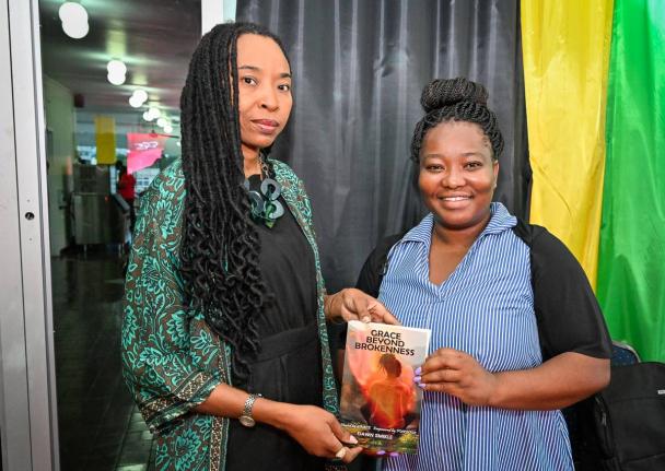 Senior Director at the National Gallery of Jamaica Dr Nadine Boothe-Gooden (left) joins author and philanthropist Dawn Smikle in displaying her book titled ‘Grace Beyond Brokenness ‘, during Sunday’s  Legal Deposit Day Celebration at the Ministry of 