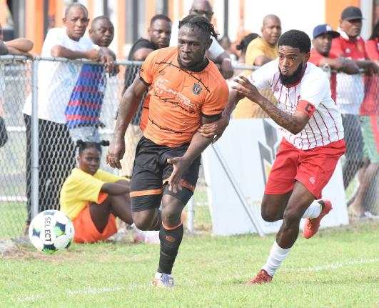  Alton Lewis (left) of Tivoli Gardens is challenged for the ball by Shakeen Powell of Dunbeholden during their Legend Jamaica Premier League match at the Edward Seaga Sports Complex yesterday.