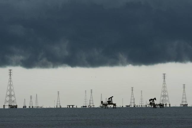 Pumpjacks and power transmission towers on Lake Maracaibo in Cabimas, Venezuela.