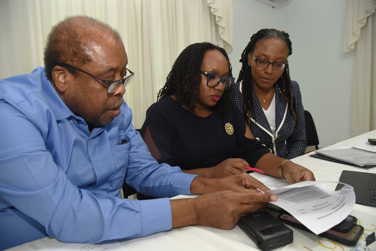 Trade unionist Lambert Brown (left) goes through documents with Dr Jubilee Brown-Service (centre), president of the Jamaica Medical Doctors' Association (JMDA) and Dr Renee Badroe (right), Immediate Past President of the JMDA, during a press conference at 