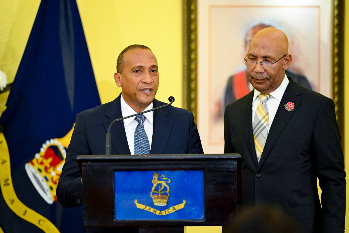 Governor-General, His Excellency Sir Patrick Allen (right), looks on as newly appointed Custos Rotulorum for St Elizabeth, Bernard Henry (left), takes the Oath of Office during a swearing-in ceremony at King's House on Thursday, October 15.