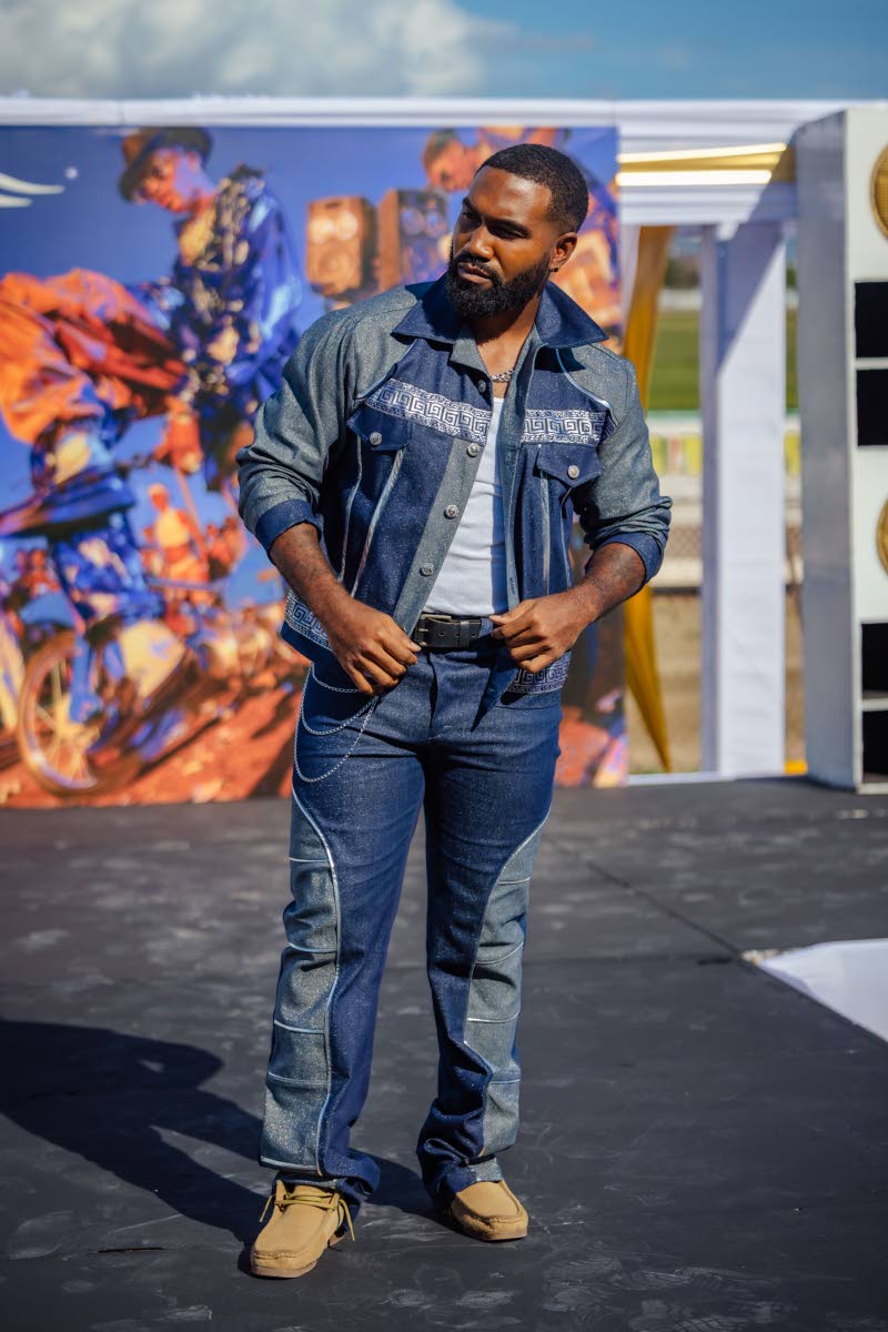 Darron Donaldson shows off Biggie’s ‘hip’ dancehall piece featuring a sparkling denim suit, a cropped jacket and trousers adorned with chains, completed by classic Clarks Wallabee footwear. 