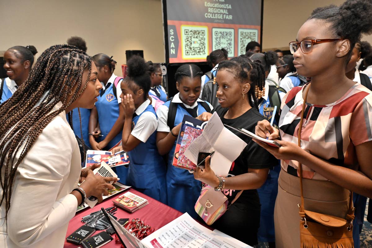 Destyni Peoples (left), international student services recruiter at Troy University in Alabama, speaks with students at the EducationUSA College Fair.