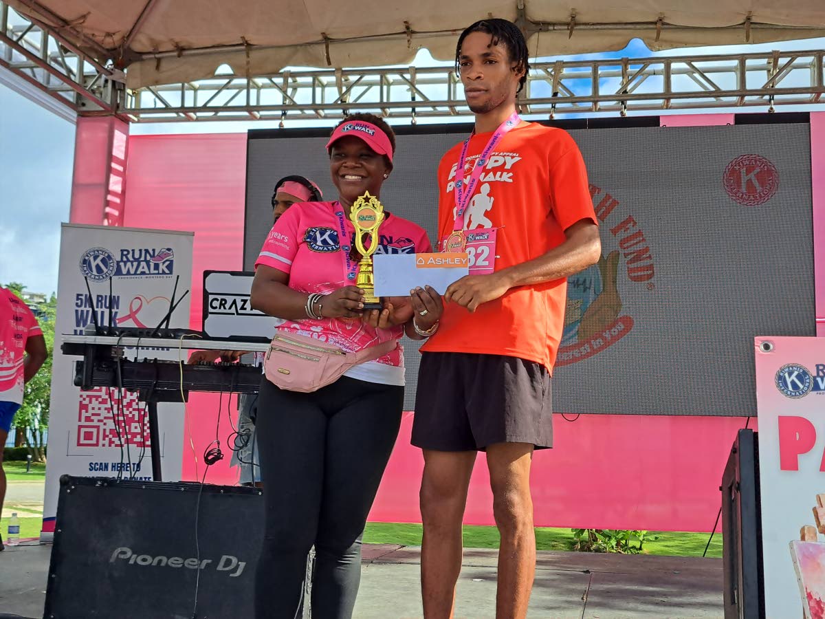 Jahvon Wilson (right), the first-place winner of the men’s division in the Kiwanis Club of Providence – Montego Bay’s 17th annual 5K, accepts his prizes from club president Gisele Waldron.
