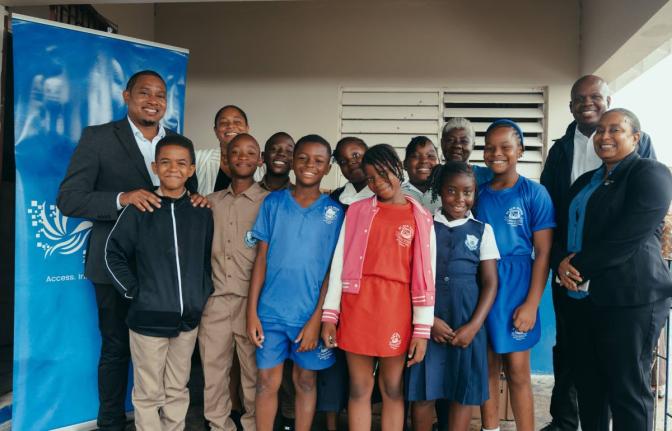 From left: Floyd Green, member of parliament for St Elizabeth South Western; with Jamaica Technology and Digital Alliance (JTDA) President Raquel Seville; Black River Primary students; Principal Sharon Whyte; JTDA Immediate Past President Almando Cox; and 