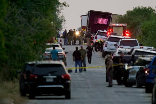 FILE - Police and other first responders work the scene where officials say dozens of people have been found dead and multiple others were taken to hospitals with heat-related illnesses after a tractor-trailer containing suspected migrants was found on Jun